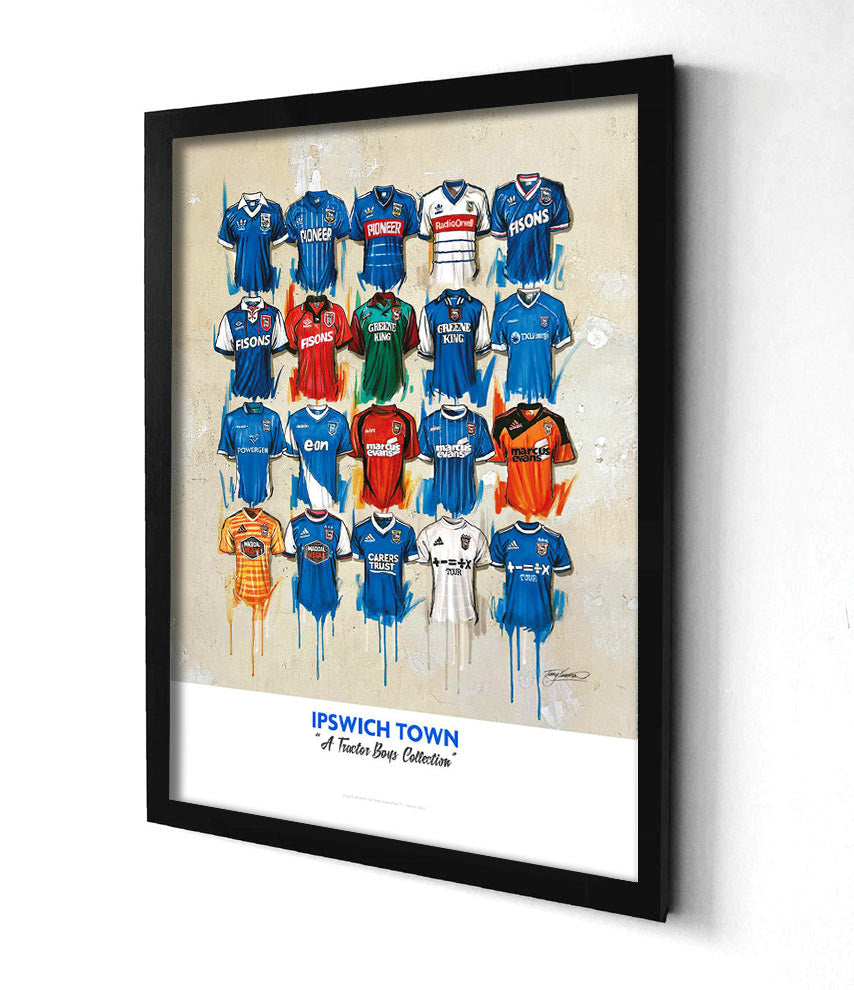 The alt text for Ipswich artwork by Terry Kneeshaw, a limited edition A2 print featuring 20 iconic Ipswich jerseys, could be: "A high-quality print of a hand-painted original artwork by Terry Kneeshaw depicting 20 iconic Ipswich jerseys. The print is in A2 size and available in both framed and unframed versions. The jerseys are displayed on a plain white background and feature the Ipswich crest and sponsor logos. The artwork uses textured brush strokes to create a dynamic effect.