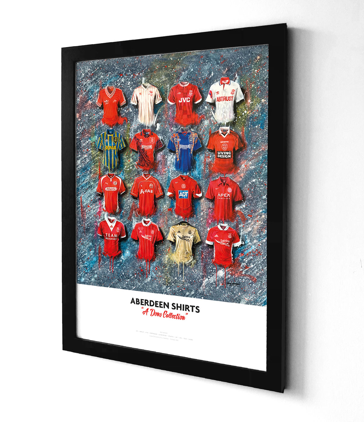 Aberdeen Shirts Football Art Framed Print. Artwork by Terry Kneeshaw depicting a collection of twenty iconic Aberdeen home and away jerseys, selected by the fans. The kits are predominantly red or white with black and gold accents and feature the Aberdeen crest, kit manufacturer, and shirt sponsor logos on the front. The artwork is a high-quality print of a hand-painted original, which uses textured brushstrokes to create a dynamic effect.